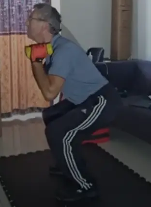 showing the dual dumbbell squat form (side view)