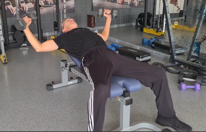 Showing the Incline Bench Dumbbell Fly gym exercise to build the Upper Chest Muscles